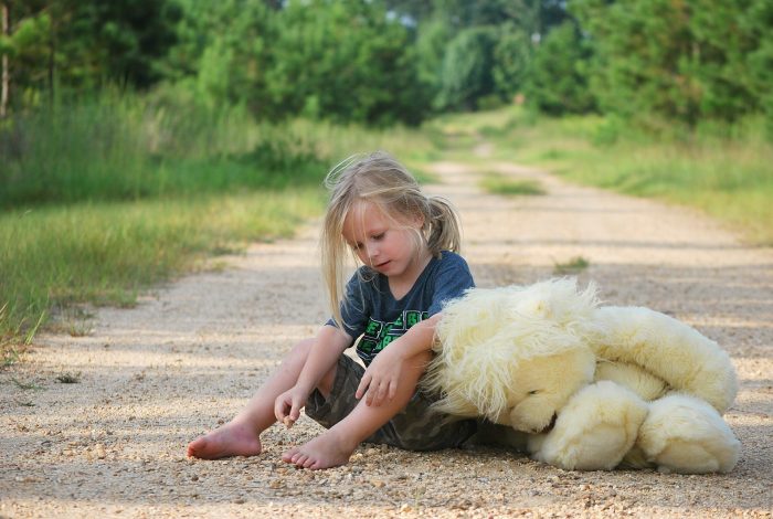 Mädchen_sitzt auf Waldweg